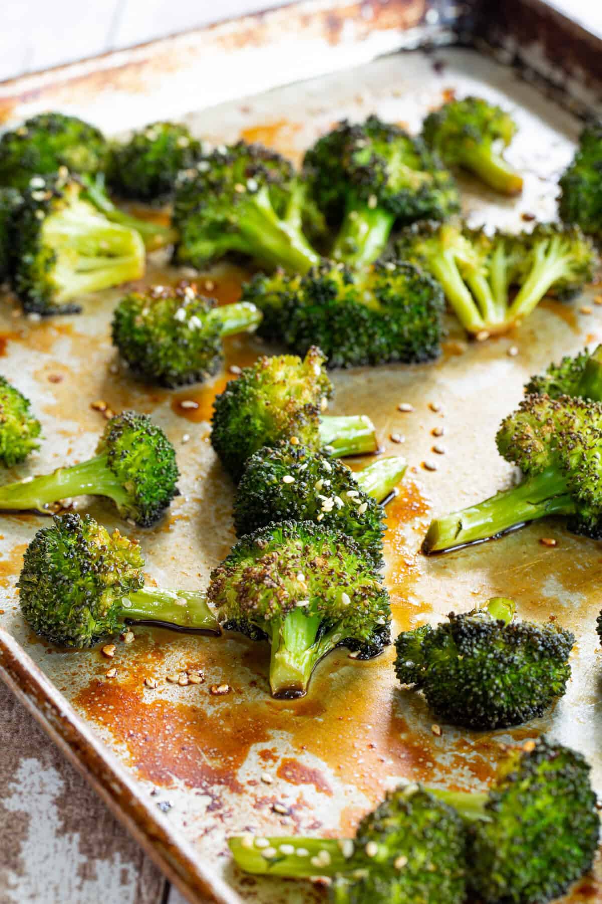 Glazed roasted broccoli on a sheet pan.