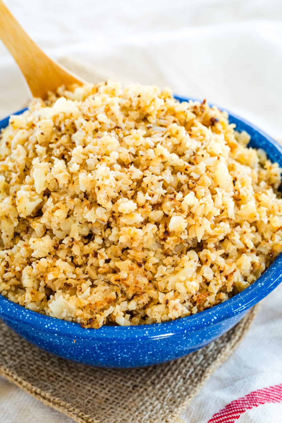 A spoon in a bowl of cauliflower rice.