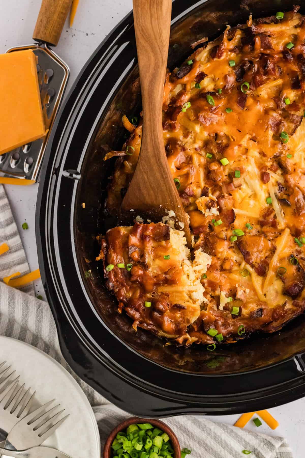 Overhead view of a wooden spoon in a breakfast casserole in the crockpot