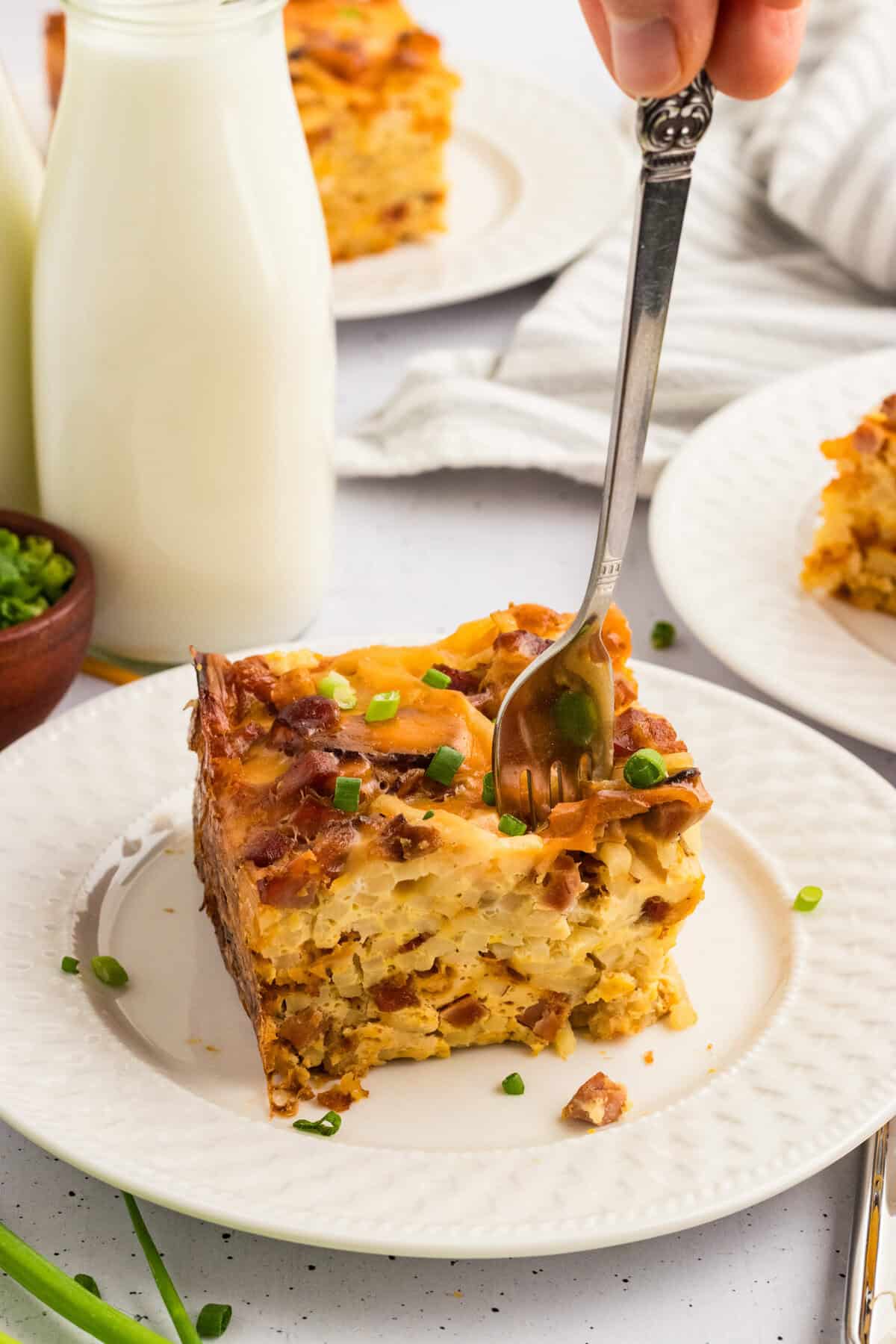 A fork standing up in a slice of crockpot breakfast casserole