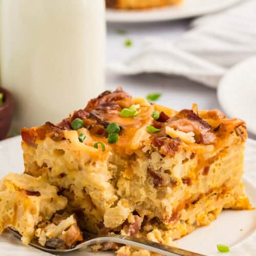 A square slice of crockpot breakfast casserole with a fork next to it