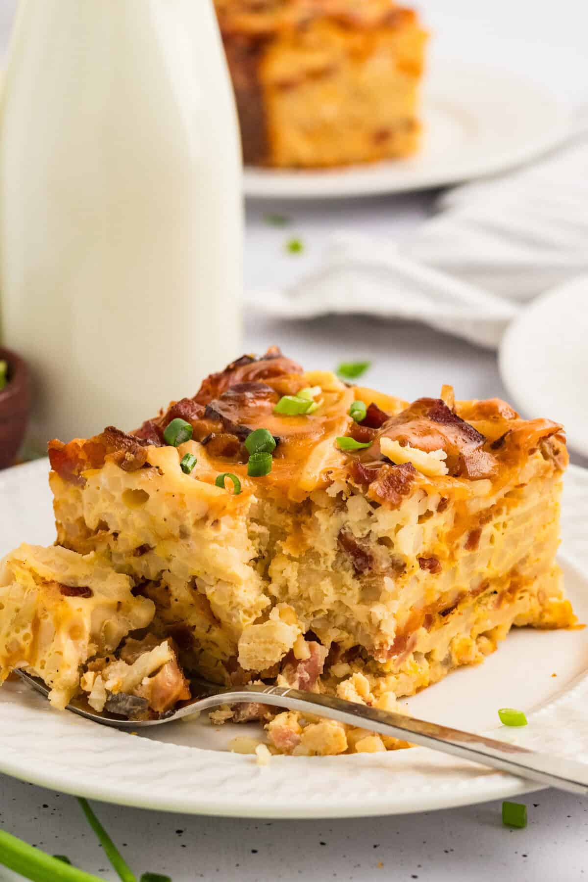A square slice of crockpot breakfast casserole with a fork next to it