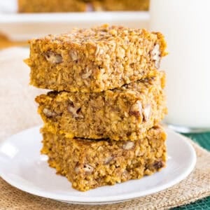Three pumpkin breakfast bars stack on a plate.