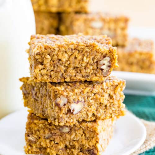 Pumpkin breakfast bars made with oats and quinoa in a stack on a plate.