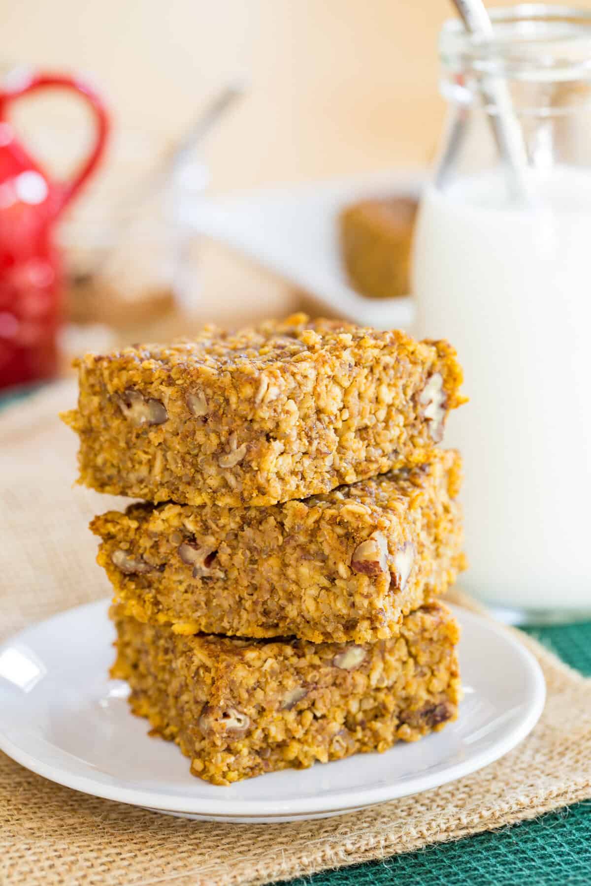 Pumpkin breakfast bars made with oats and quinoa in a stack on a plate.