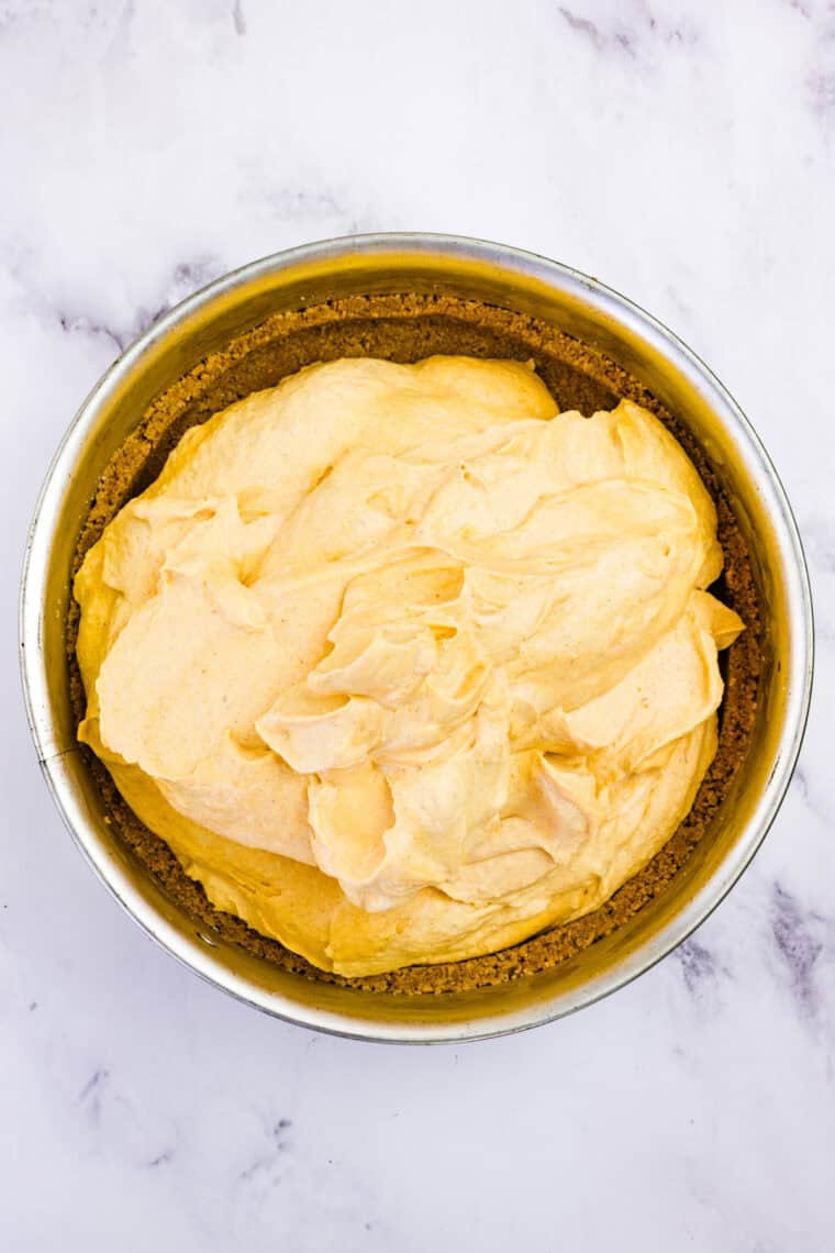 With a graham cracker crust and fluffy pumpkin filling, this gluten free no-bake pumpkin cheesecake is an easy fall dessert. Pumpkin cheesecake filling added to graham cracker crust
