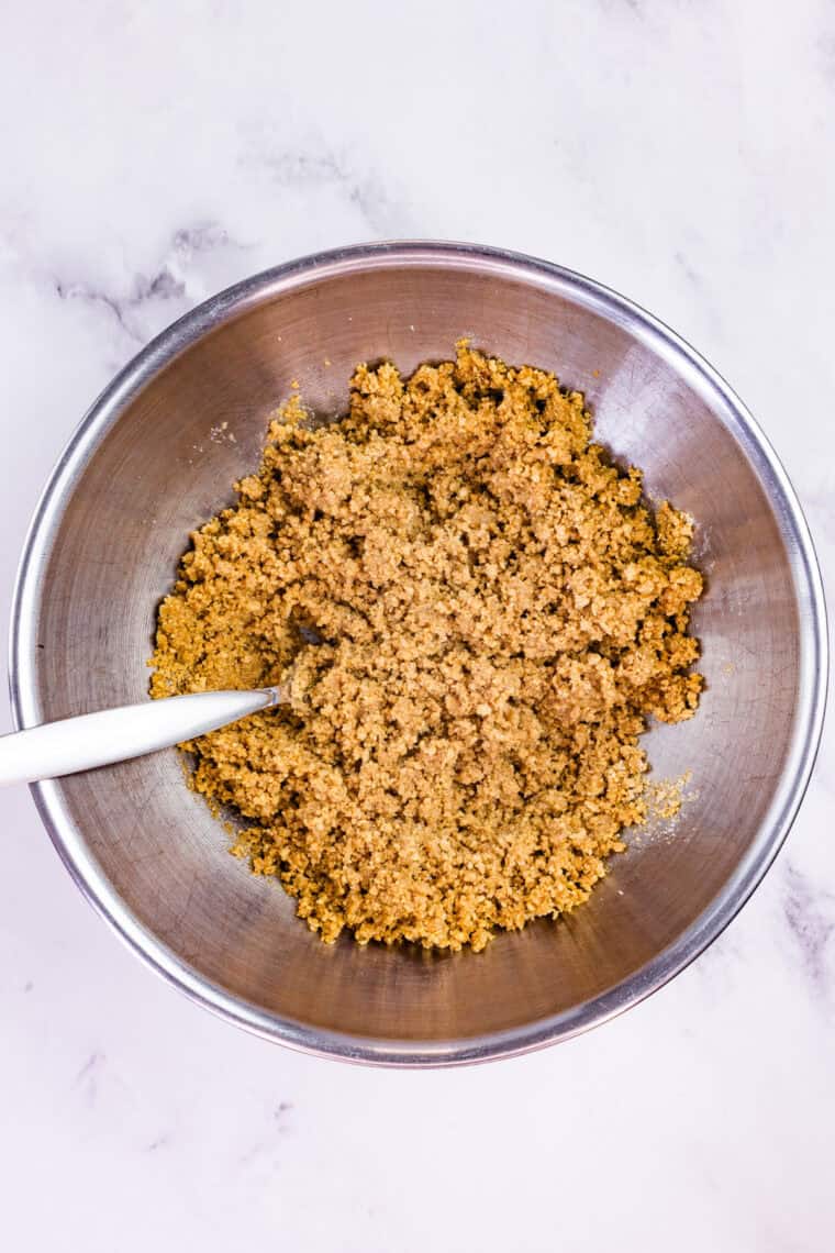 With a graham cracker crust and fluffy pumpkin filling, this gluten free no-bake pumpkin cheesecake is an easy fall dessert. Stirring butter into graham cracker crumbs