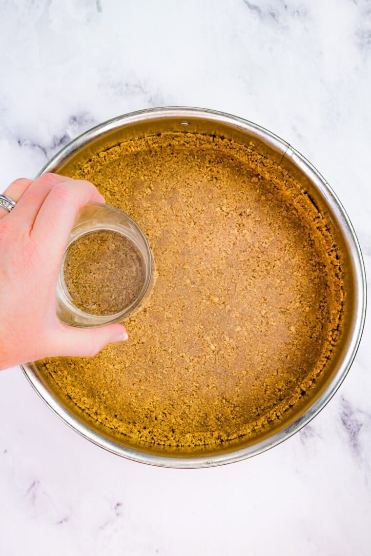 With a graham cracker crust and fluffy pumpkin filling, this gluten free no-bake pumpkin cheesecake is an easy fall dessert. Pressing graham cracker crust into a springform pan